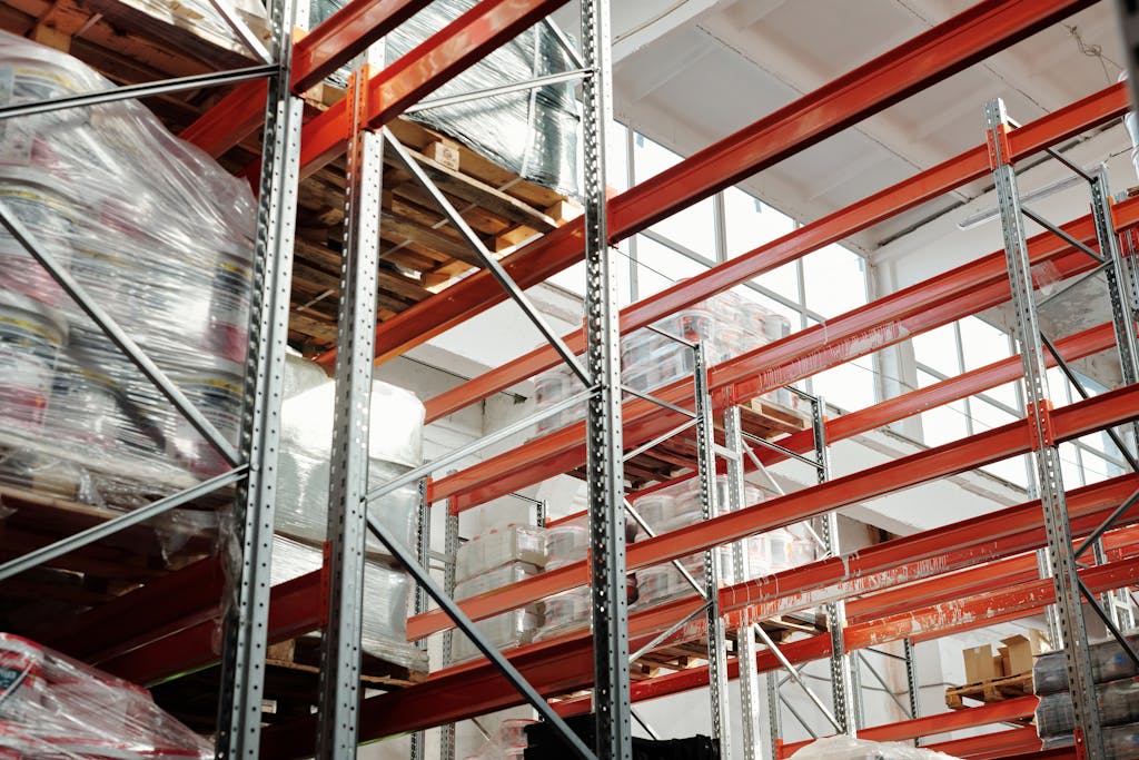 Bright modern warehouse featuring pallets and storage racks for logistics and inventory management.